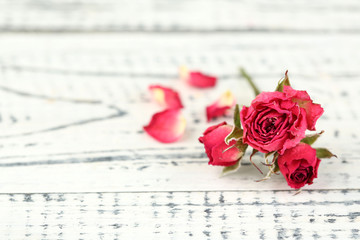 Beautiful pink dried roses on old wooden background