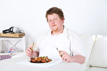 Tasty lunch for fat man, on home interior background