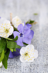 Fototapeta na wymiar Beautiful bouquet with periwinkle flowers on wooden table