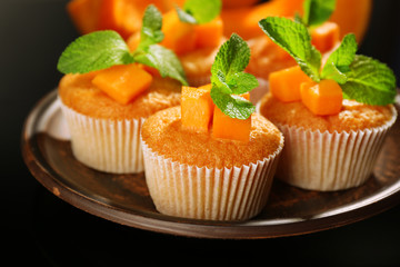 Tasty pumpkin muffins on dark background