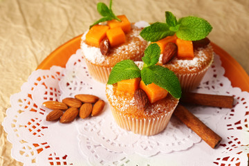 Tasty pumpkin muffins on brown paper