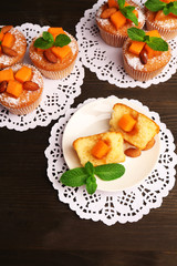 Tasty pumpkin muffins on wooden table