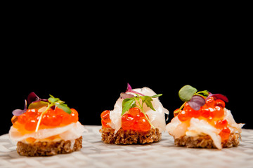 Salmon eggs, fish, and herbs canapes
