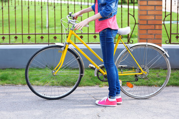 Naklejka premium Young woman with bicycle outdoors