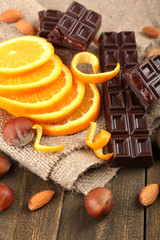 Chocolate, orange and nuts on wooden table