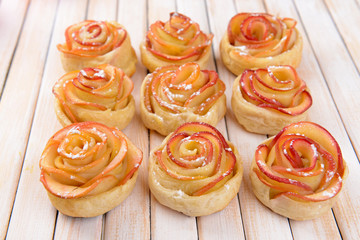 Obraz na płótnie Canvas Tasty puff pastry with apple shaped roses on table close-up