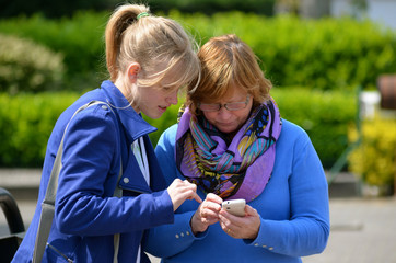 woman and girl looking at cellphone