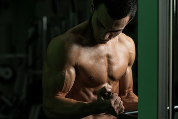 Fototapeta na wymiar Bodybuilder Exercising Biceps In A Gym