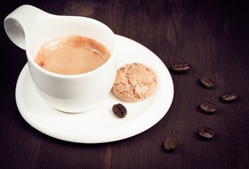 cup of espresso coffee and biscuit near coffee beans, old style
