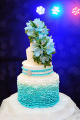beautiful turquoise three-tiered wedding cake on table