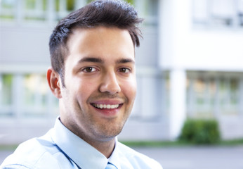 Young businessman with blue tie looking at camera