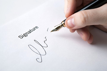 pen in the man's hand and signature