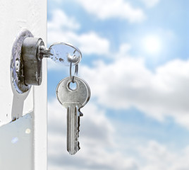 Keys in a lock with sky background
