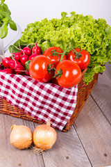Korb mit Gemüse auf rustikalem Hintergrund