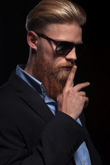 bearded business man with finger at mouth