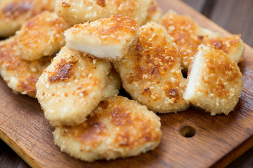 Wooden chopping board with nuggets, horizontal shot