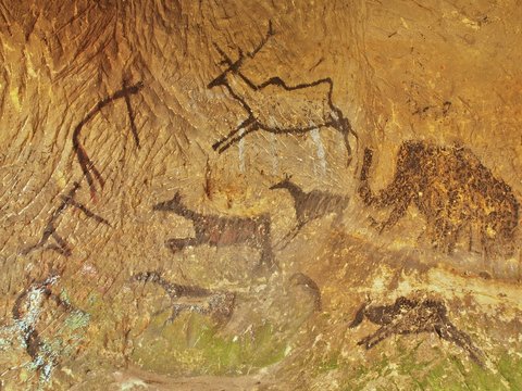 Abstract children art in sandstone cave. Paint of human hunting.