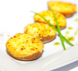 Baked potatoes with greens and spices on plate