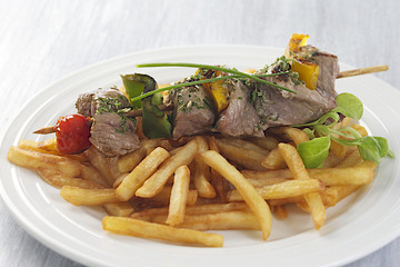 Tasty grilled meat  skewers with French fries potatoes