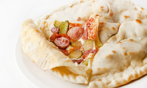 closed pizza with Bavarian sausages and pickles