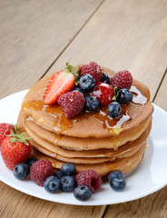 Pancakes with berries and honey closeup