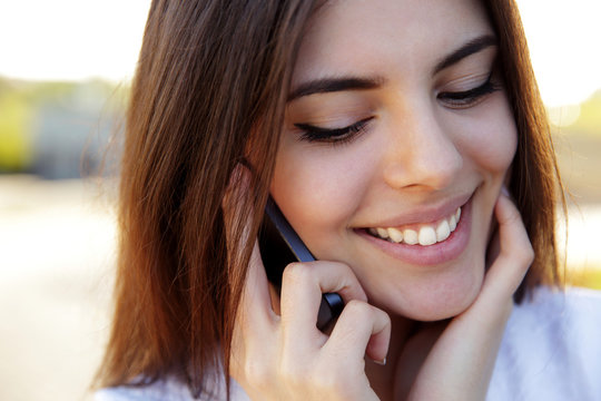 Beautiful Happy Woman Speaking On The Phone Outdoors