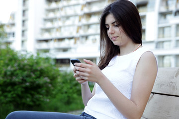 Fototapeta premium Beautiful woman sitting on the outdoor bench