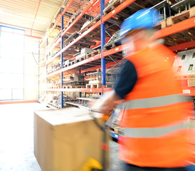Mann mit Hubwagen im Lager // shipping industry