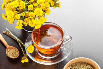 healthy tea closeup, bucket with coltsfoot flower