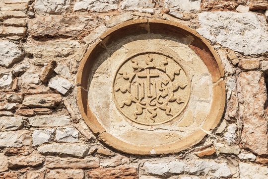 JHS-Symbol in der Einsiedelei "Carceri", Assisi,  Umbrien, Italien