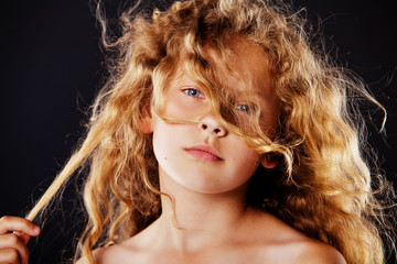 Portrait of little girl with windy hair. Fashion photo
