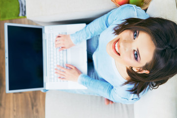 Woman with laptop looking up.