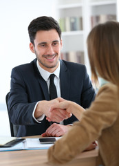 Woman giving handshake to financial adviser