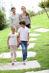 Fototapeta premium Happy family of four walking towards home