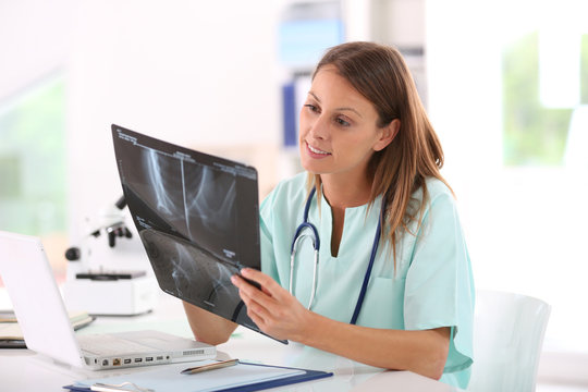 Nurse reading X-Ray results in hospital office