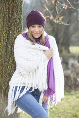 Junge Frau mit weissem Strickponcho, Schal und Mütze