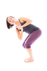 Fototapeta premium Young woman practicing yoga in chair pose