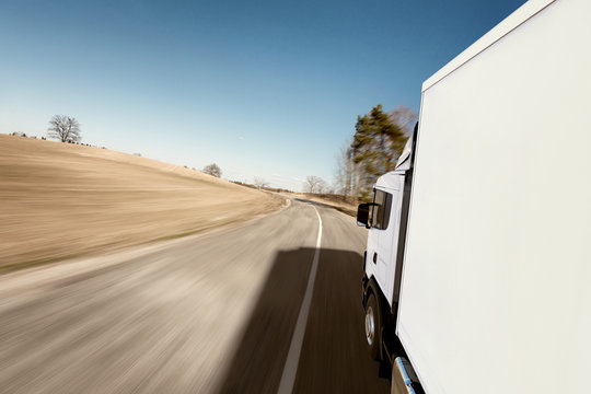 Truck on the road. 3D render on photographic background.