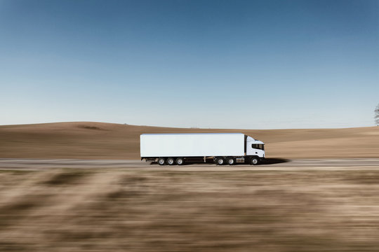 Truck on the road. 3D render on photographic background.