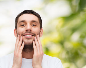 beautiful smiling man touching his face