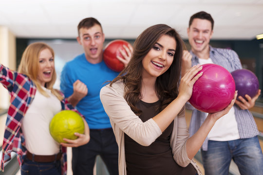 Portrait of young woman with friends at bowling alley