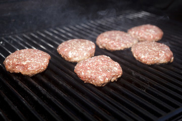 Hamburger patties cooking on a grill