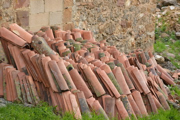 tejas apiladas en un muro de piedra