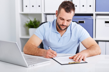 Young businessman in blue polo shirt signs a contract