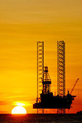 Silhouette of an offshore drilling rig at sunset
