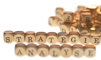 Worte "Strategie" und "Analyse" aus Buchstabenwürfeln, freigestellt, Freisteller, Fokus auf Strategie
