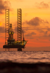 Silhouette of an offshore oil rig at sunset