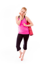 Young woman carrying exercising mat looking sad