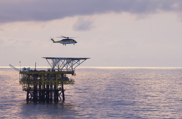 A helicopter transports roughnecks to a rig