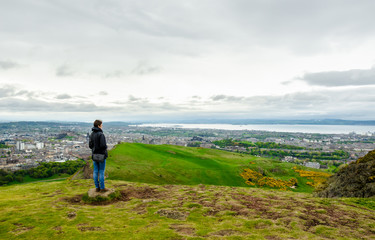 Young female model admiring Edinburgh landscape from the top of